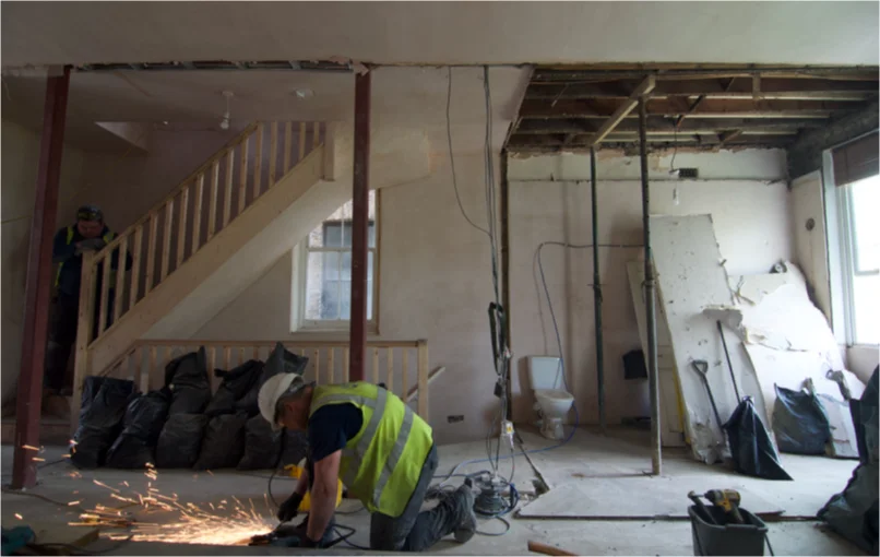 This image depicts a wide lens picture of off the first floor which has almost 3 meter high ceilings a part of the ceiling torn down exposing the old timbers.