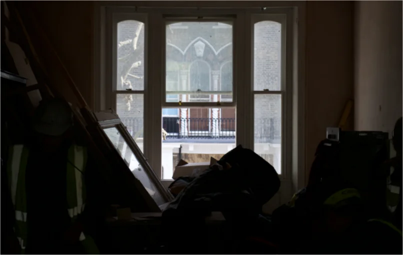 This image depicts a large 3 sash Victorian style window with light beaming through it and entering a large open plan room.