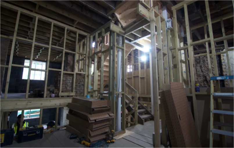 This image depicts an empty room which is under construction, has 3 meter high ceilings and only has stud walls put up.